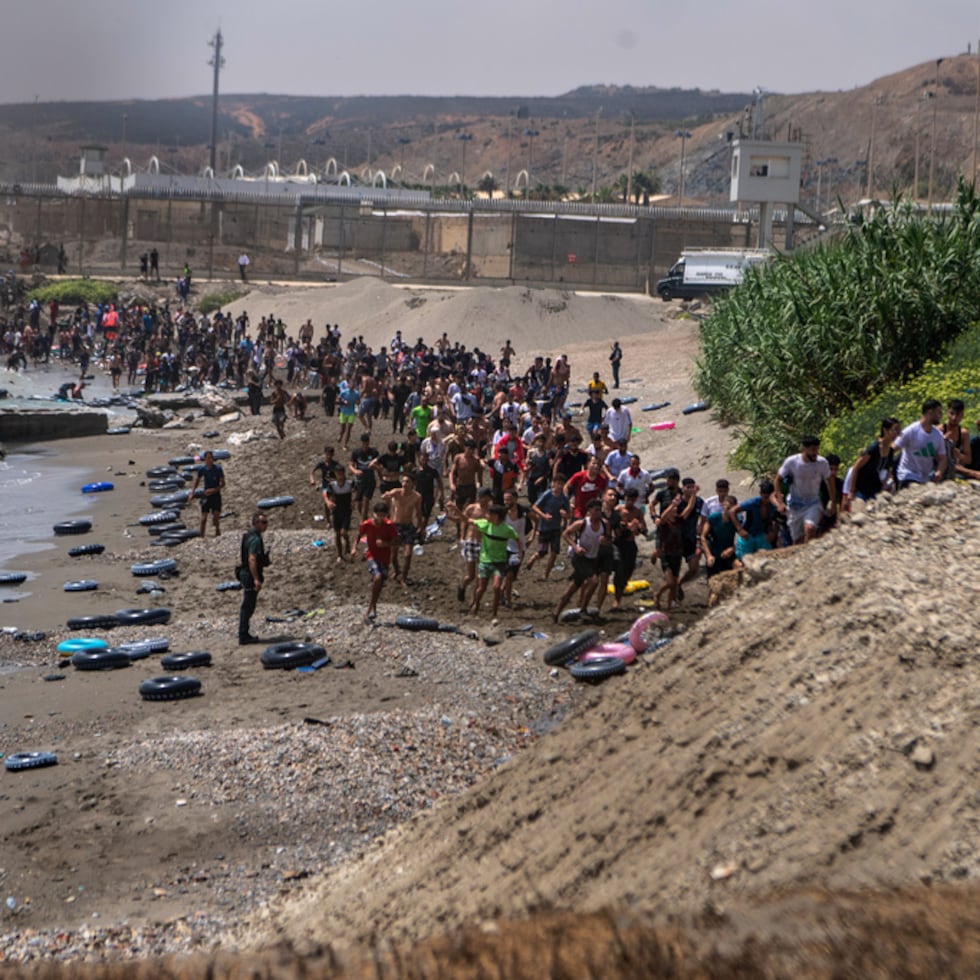 Videos grabados en la playa del Tarajal mostraban multitudes de personas, en su mayoría marroquíes, caminando alrededor de los rompeolas hacia las carreteras locales.