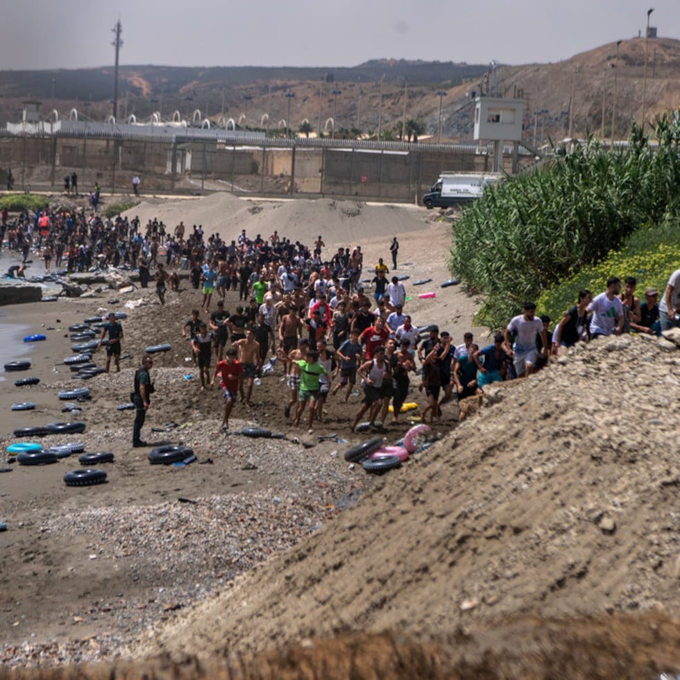 Videos grabados en la playa del Tarajal mostraban multitudes de personas, en su mayoría marroquíes, caminando alrededor de los rompeolas hacia las carreteras locales.