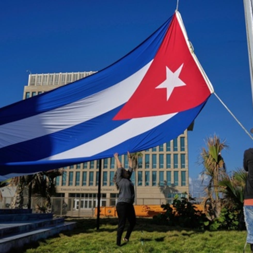 Trabajadores ondean la bandera cubana a media asta en la Tribuna Antiimperialista cerca de la Embajada de Estados Unidos en La Habana, Cuba, el lunes 5 de enero, en memoria de los cubanos que murieron en Caracas, Venezuela, durante la captura del presidente venezolano Nicolás Maduro por fuerzas estadounidenses.