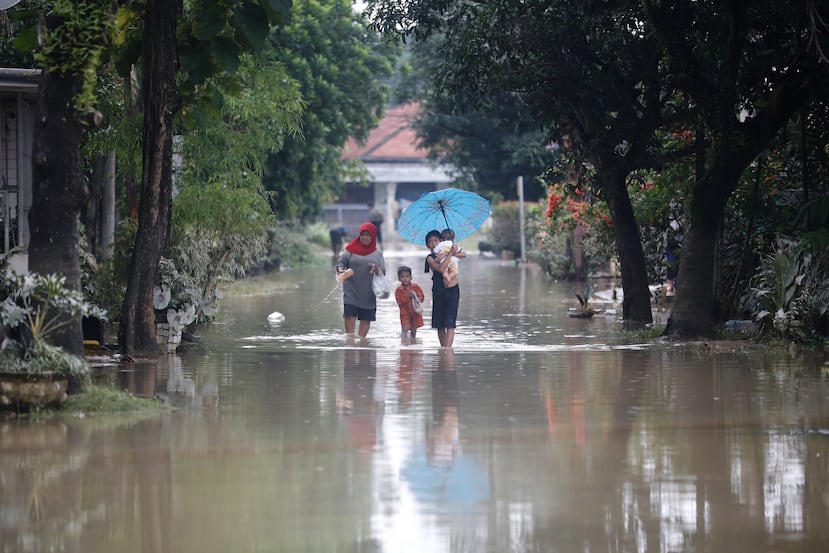 La gente camina a través del agua en un barrio inundado de Medan, Sumatra del Norte, Indonesia, el viernes 28 de noviembre de 2025. (Foto AP/Binsar Bakkara)