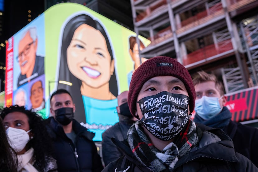 Una persona con una mascarilla con la leyenda "Basta de Odio a Asiáticos" asiste a una vigilia en memoria de Michelle Alyssa Go, víctima de un ataque en el metro días antes, 18 de enero de 2022 en Times Square de Nueva York.