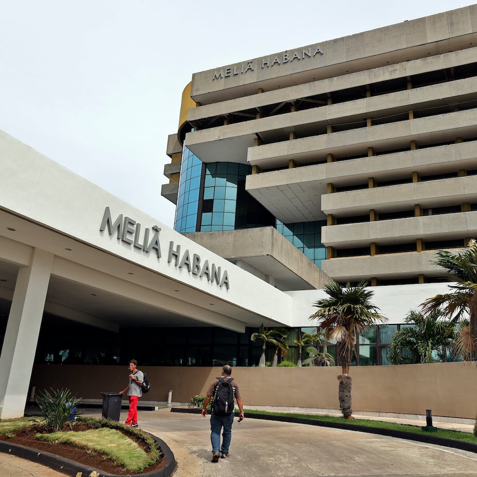 Personas caminan frente a la entrada de un hotel de Melia este miércoles, en La Habana (Cuba).