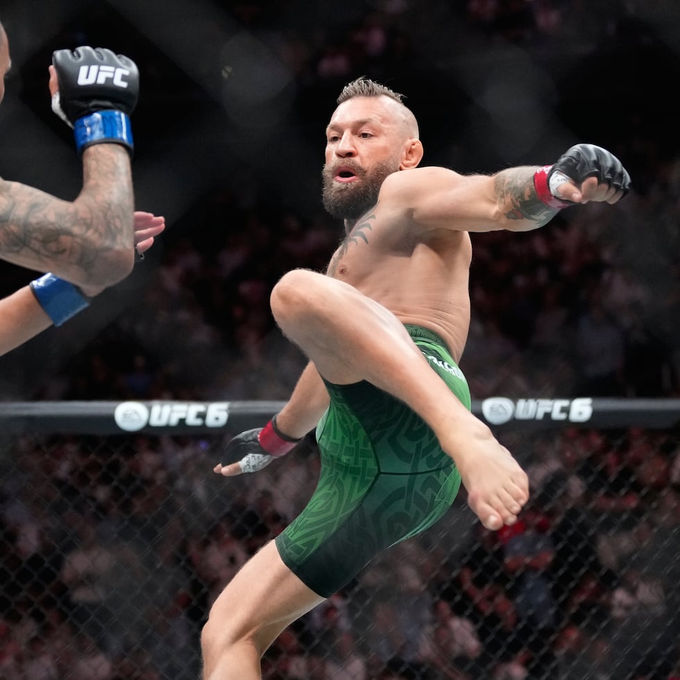 Conor McGregor lanza una patada contra Max Holloway antes de lastimarse la rodilla derecha.