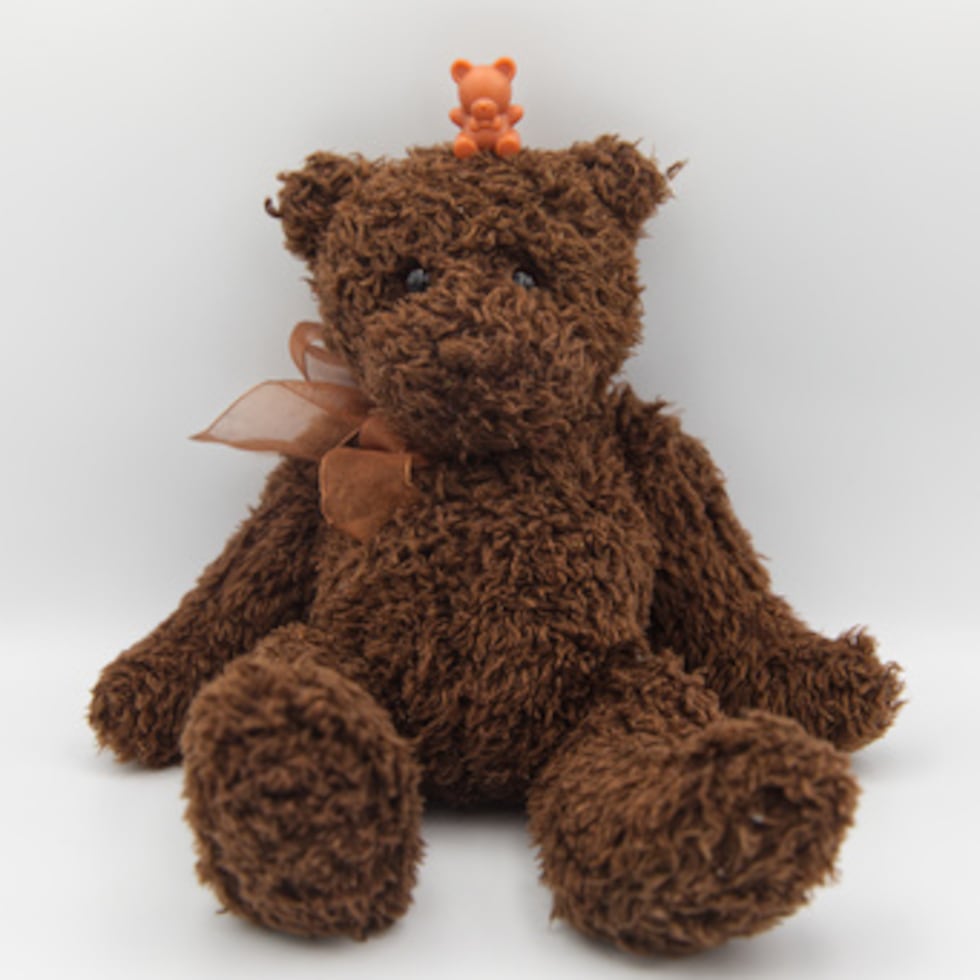 Un oso de peluche de plástico en miniatura se sienta encima de un oso de peluche en Phoenix.