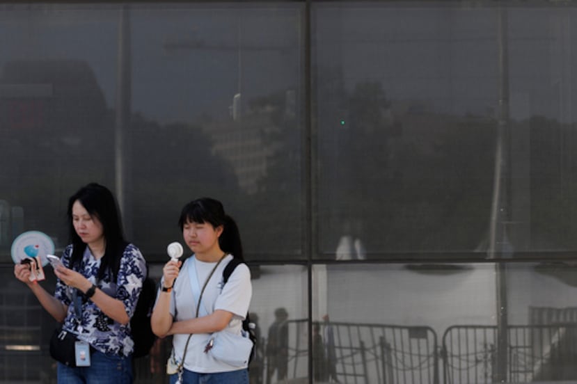 ARCHIVO - Los visitantes utilizan abanicos mientras esperan para entrar en el Monumento a Washington, el 1 de julio de 2026, en Washington. (Foto AP/Tom Brenner, archivo)