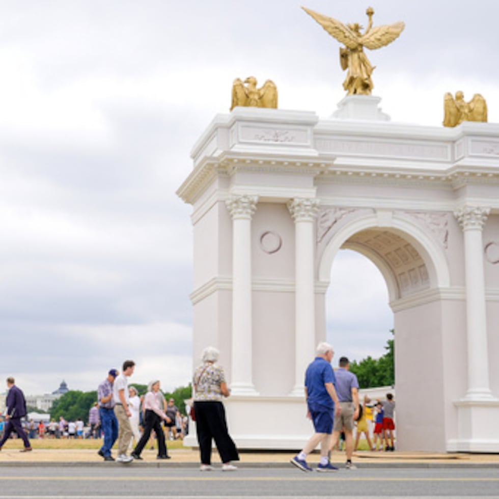 Los visitantes pasean por la Great American State Fair con la maqueta del arco del triunfo y el Capitolio de los Estados Unidos al fondo, el miércoles 8 de julio de 2026, en Washington.