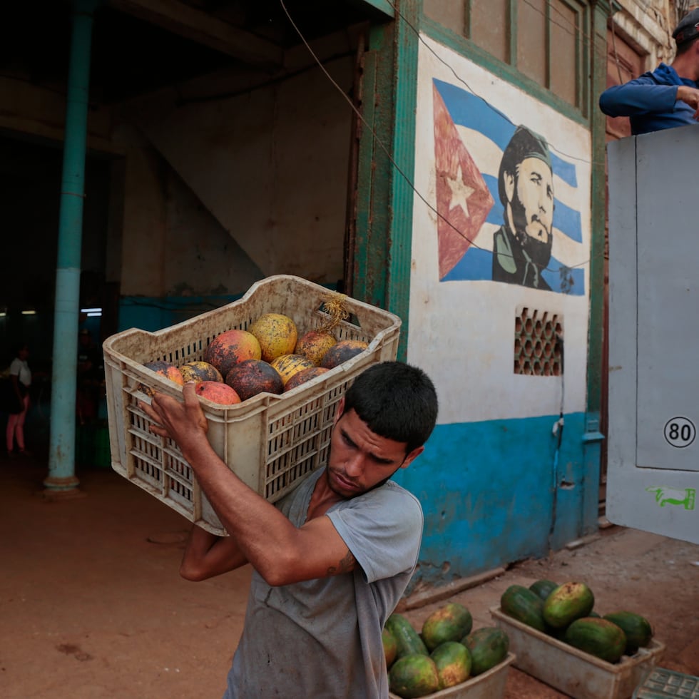 Un trabajador descarga cajas de fruta en un mercado estatal en La Habana, Cuba.