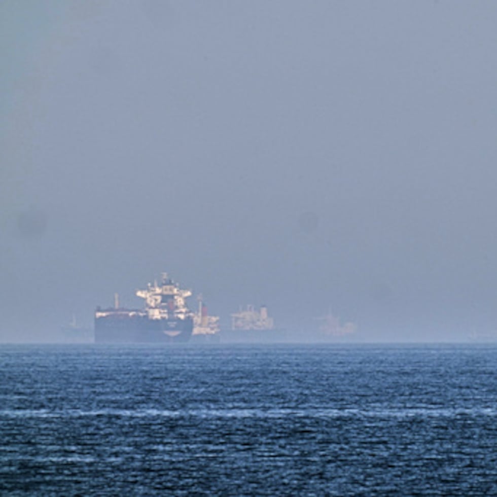 Un petrolero (izquierda) y un barco con autos, fondeados en el golfo de Omán, cerca del estrecho de Ormuz.