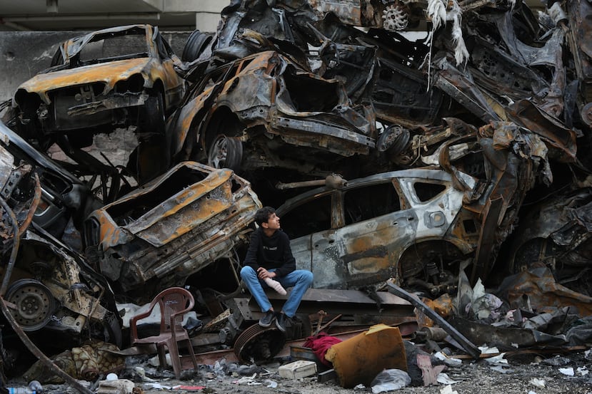 Un hombre se sienta junto a coches calcinados y escombros tras el bombardeo israelí del miércoles anterior, en el centro de Beirut, Líbano, el martes 14 de abril de 2026. (Foto AP/Hassan Ammar)