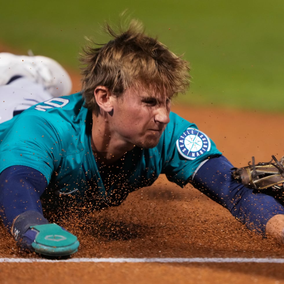 Colt Emerson, de los Mariners de Seattle, se barre y llega a salvo a tercera base durante el 'spring training'.