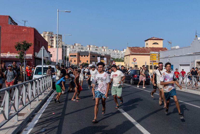 Migrantes huyen de la policía española tras cruzar desde Marruecos al enclave español de Ceuta, el viernes 31 de julio de 2026. (Foto AP/Antonio Sempere)