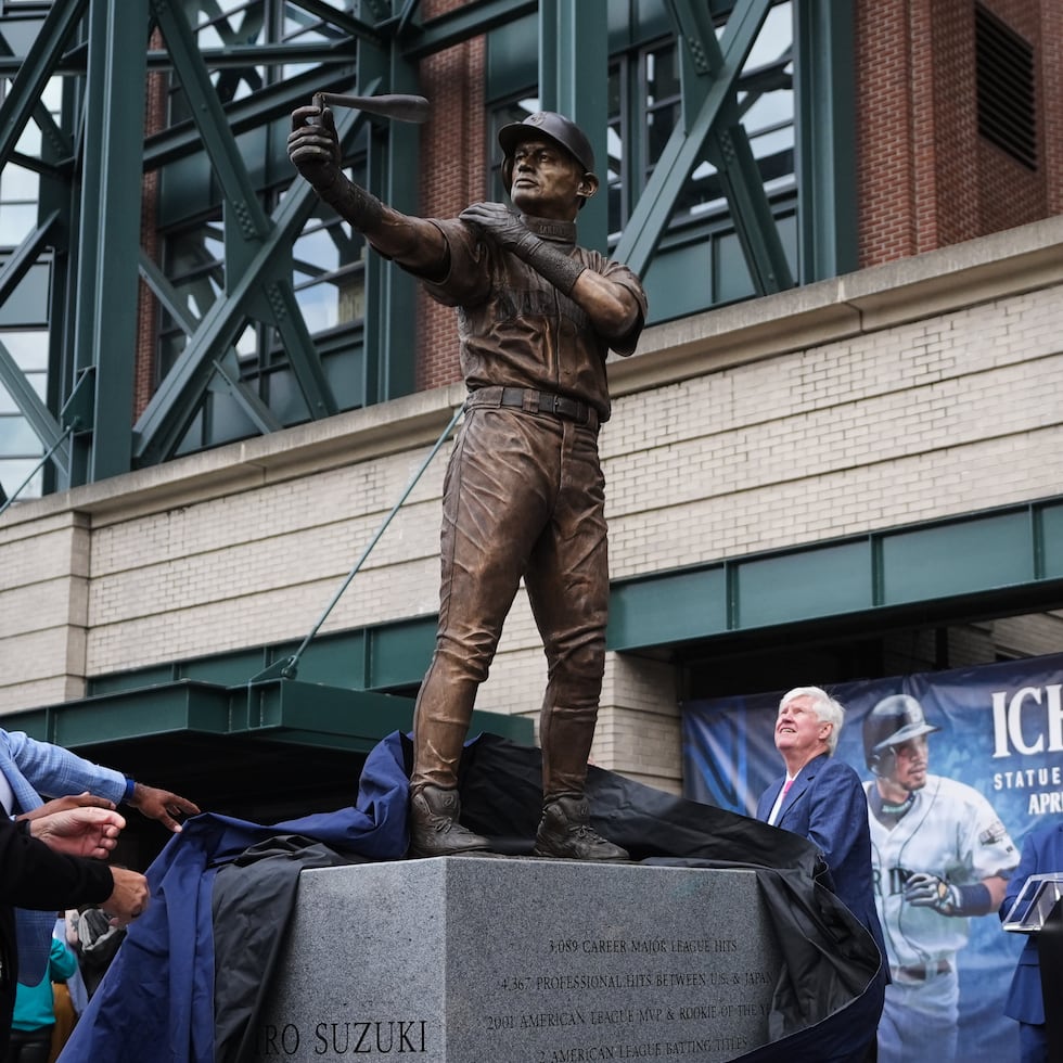 El exjugador de los Mariners, Edgar Martínez (izquierda), y Ken Griffey Jr. (segundo desde la izquierda), observan junto al jardinero derecho Ichiro Suzuki (derecha) el bate roto de la estatua del japonés durante su develación frente al T-Mobile Park, en Seattle.