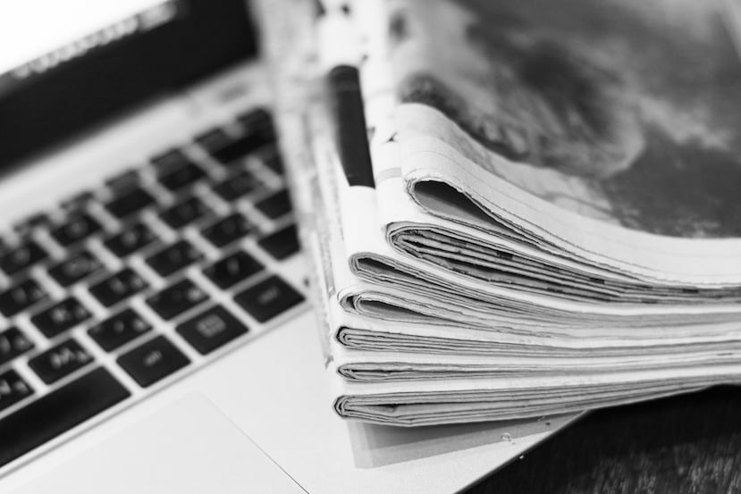 Un periódico sobre una laptop.