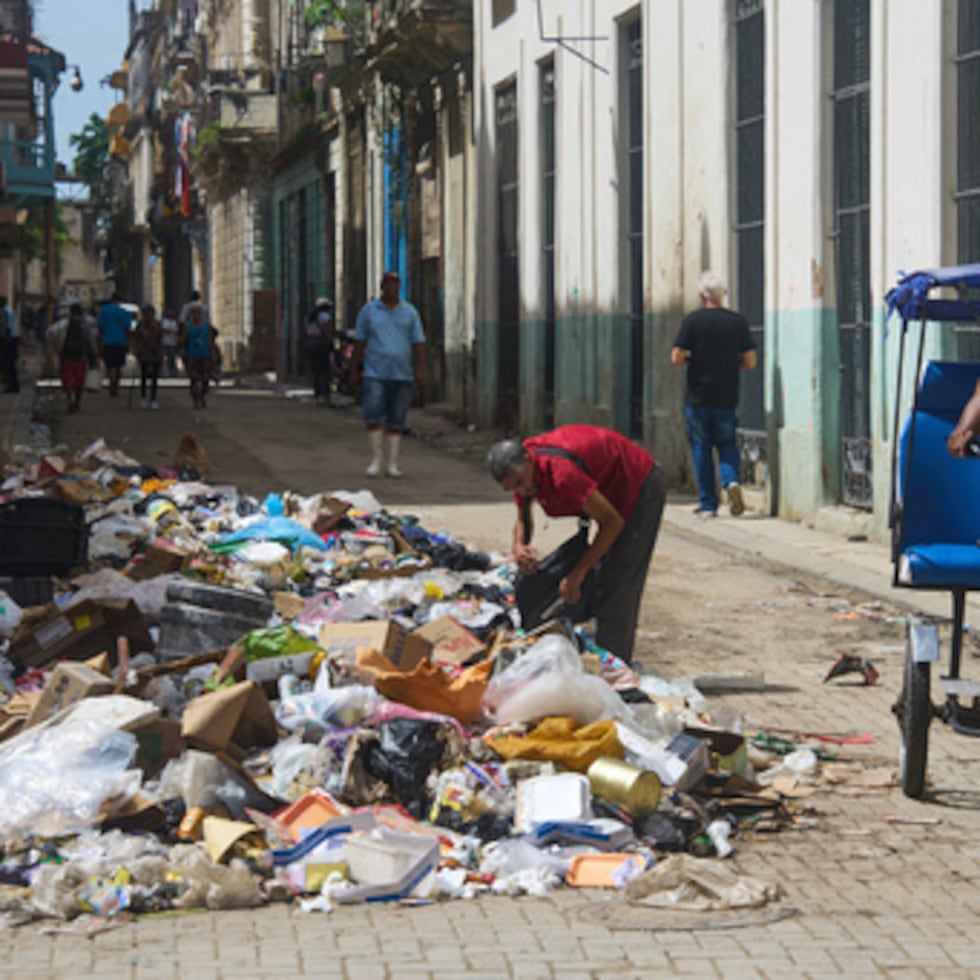 Un hombre busca entre un montón de basura objetos para salvar en La Habana.