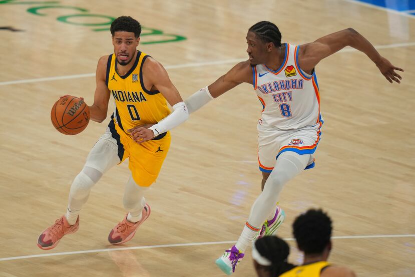 Tyrese Haliburton (0), de los Pacers de Indiana, lleva el balón hacia la canasta mientras Jalen Williams (8), del Thunder de Oklahoma City, defiende durante la primera mitad del quinto juego.