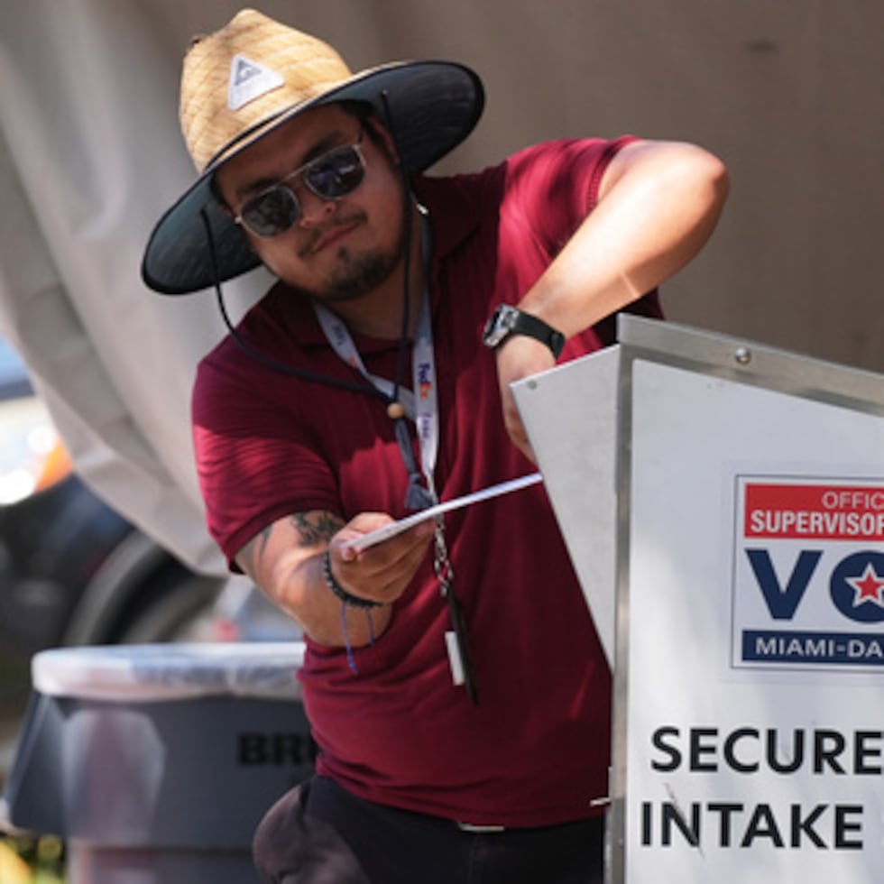 Un miembro del personal electoral deposita una papeleta de voto por correo en una urna de seguridad en la Oficina del Supervisor Electoral del condado de Miami-Dade durante las elecciones primarias de Florida celebradas en Doral (Florida), el martes 18 de agosto de 2026. (Foto AP/Lynne Sladky)