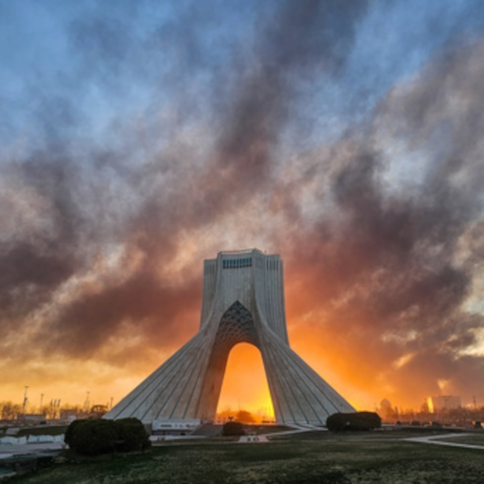 El humo se eleva detrás de Azadi, o torre de la libertad, después de un ataque militar estadounidense-israelí en Teherán, Irán, martes 3 de marzo de 2026.