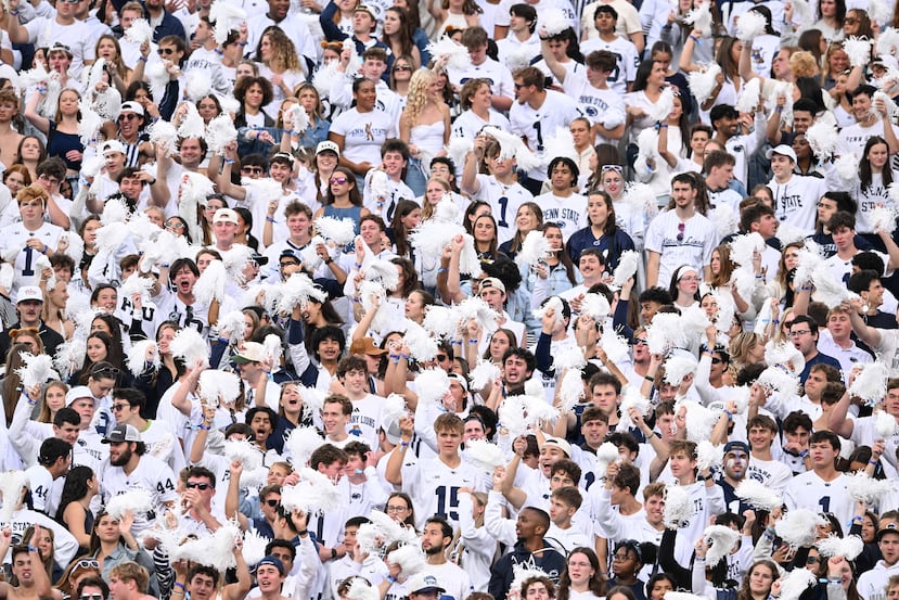 Fanáticos de Penn State gritando contra el equipo de Wisconsin en un partido de football de la NCAA.