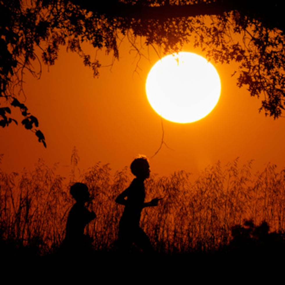 ARCHIVO - La gente se silueta contra el cielo al atardecer mientras corren en Shawnee Mission Park, 26 de septiembre 2024, en Shawnee, Kan. (AP Photo/Charlie Riedel, File)