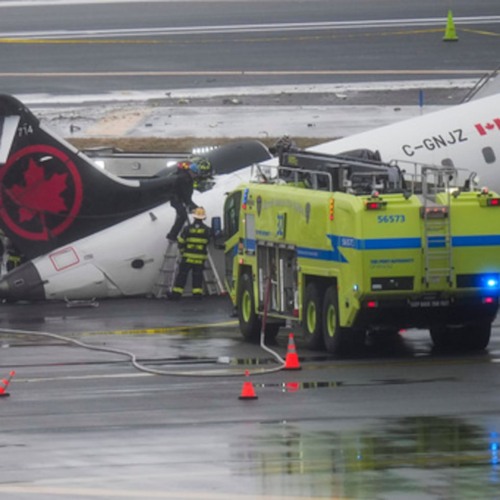 Bomberos e investigadores examinan el lugar, 23 de marzo de 2026, donde un avión de Air Canada se detuvo tras colisionar con un camión de bomberos.