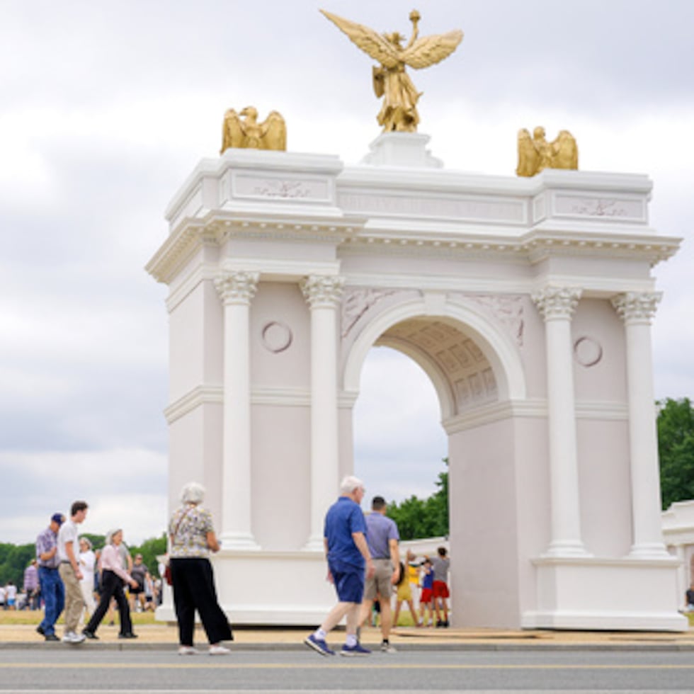 Visitantes pasean por la Great American State Fair con la maqueta del arco del triunfo y el Capitolio de los Estados Unidos al fondo.