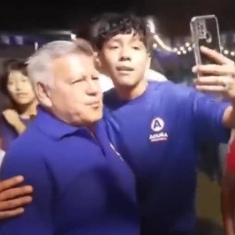 Captura de video tomada a través de rastreo de redes del empresario derechista y candidato presidencial en Perú César Acuña (i) junto a un joven que le rompió un huevo contra su cabeza durante un acto electoral.