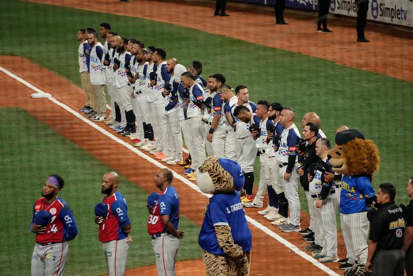 Jugadores venezolanos y dominicanos escuchan los himnos durante la Serie del Caribe de 2023 en Caracas, Venezuela.
