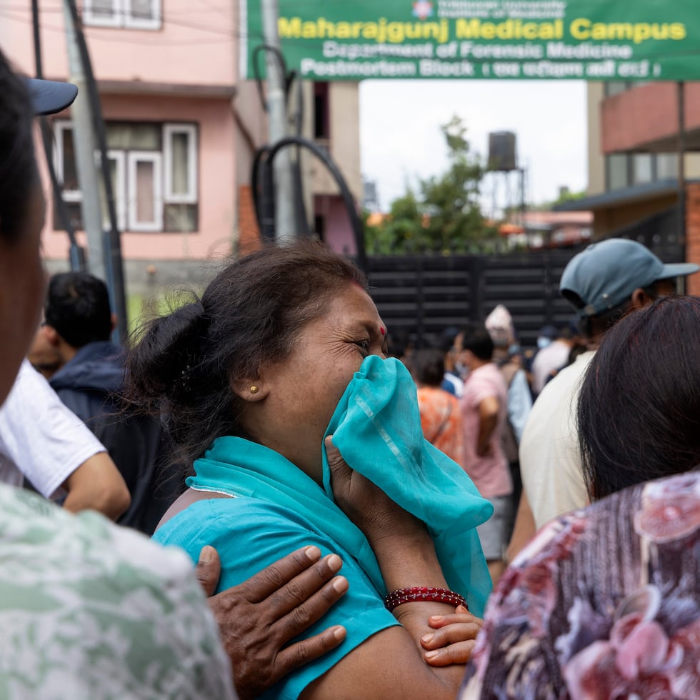 Personas lloran por familiares afectados por la riada en Nepal.