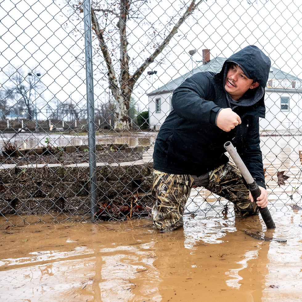 Dekoda Cruz trabaja para despejar un desagüe tras las fuertes lluvias en Redding, California.