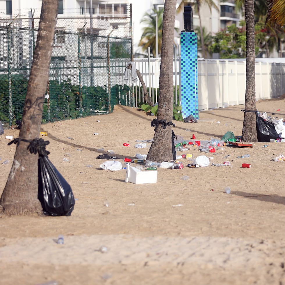 The photo shows trash and foam coolers abandoned on El Alambique Beach in Isla Verde, Carolina, following the most recent San Juan Night in June 2026.