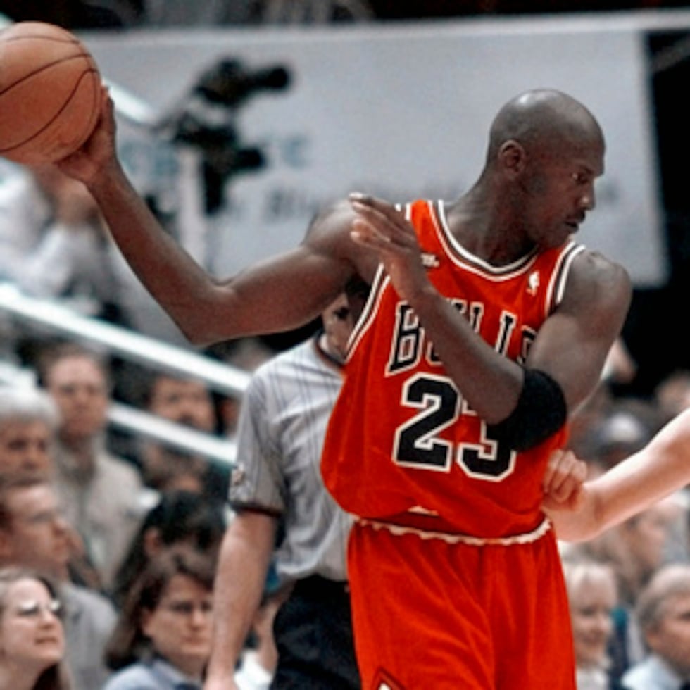Michael Jordan, de los Chicago Bulls, aleja el balón del alcance del base de los Utah Jazz, Jeff Hornacek, durante una jugada del tercer cuarto del segundo partido de las Finales de la NBA, disputado en Salt Lake City el 5 de junio de 1998.