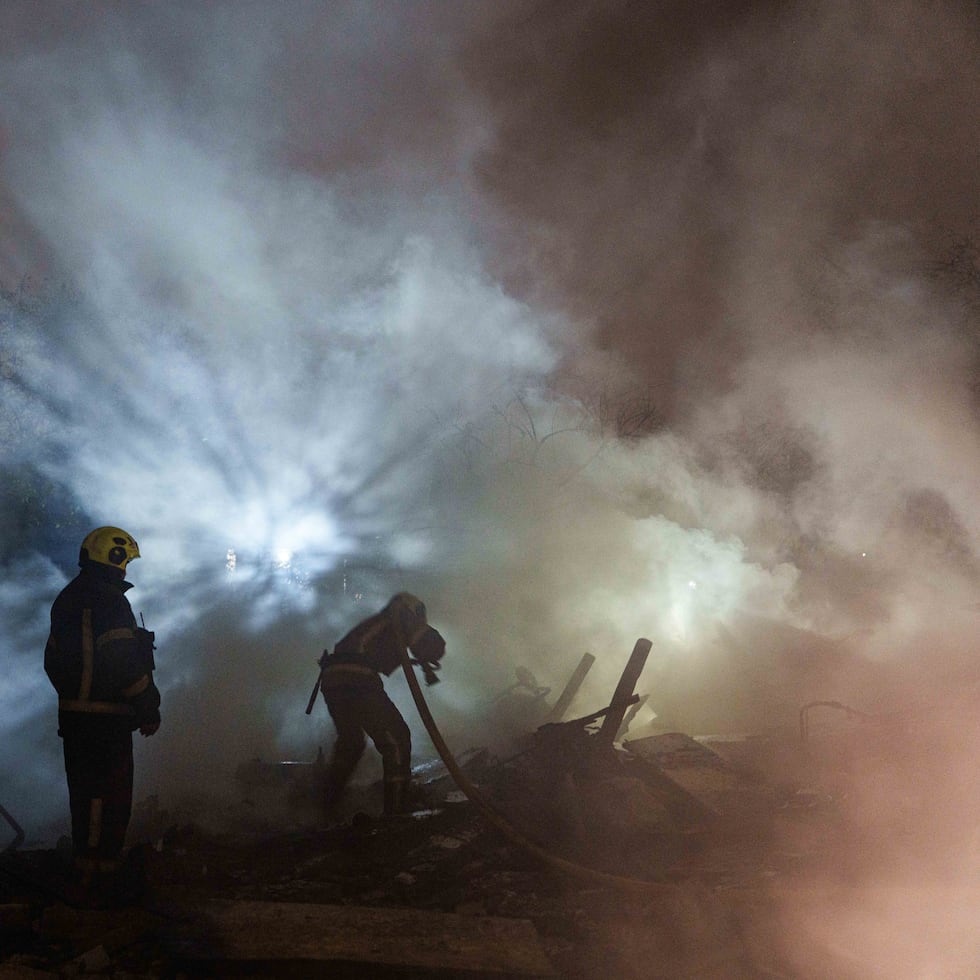 Rescatistas apagan un fuego en una residencia destruida por misiles rusos en Kiev, capital de Ucrania.
