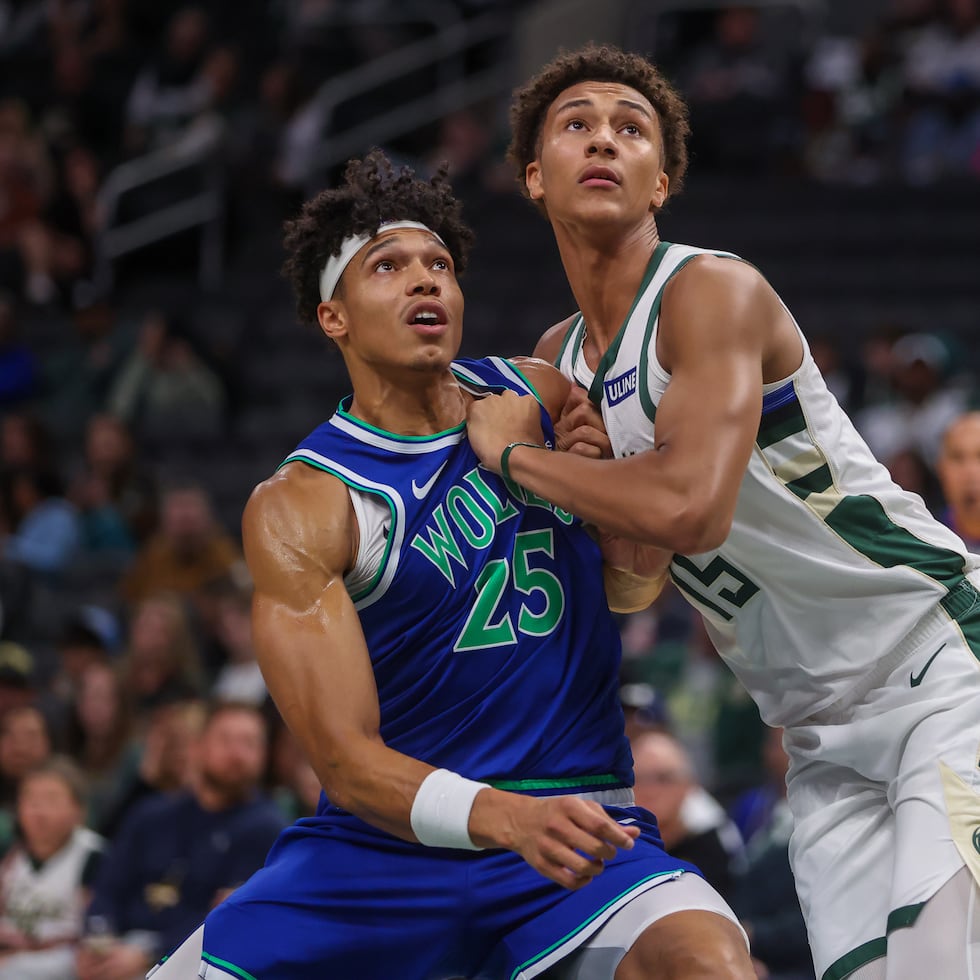 El boricua Enrique Freeman, con el uniforme de los Timberwolves, pelea por un rebote contra Nate Ament, de Milwaukee, durante un partido de pretemporada de la NBA.