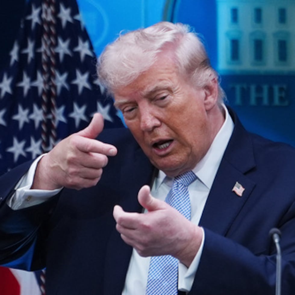 El presidente Donald Trump simula apuntar con una pistola de francotirador mientras hablaba el lunes con los periodistas en la sala de prensa James Brady de la Casa Blanca.