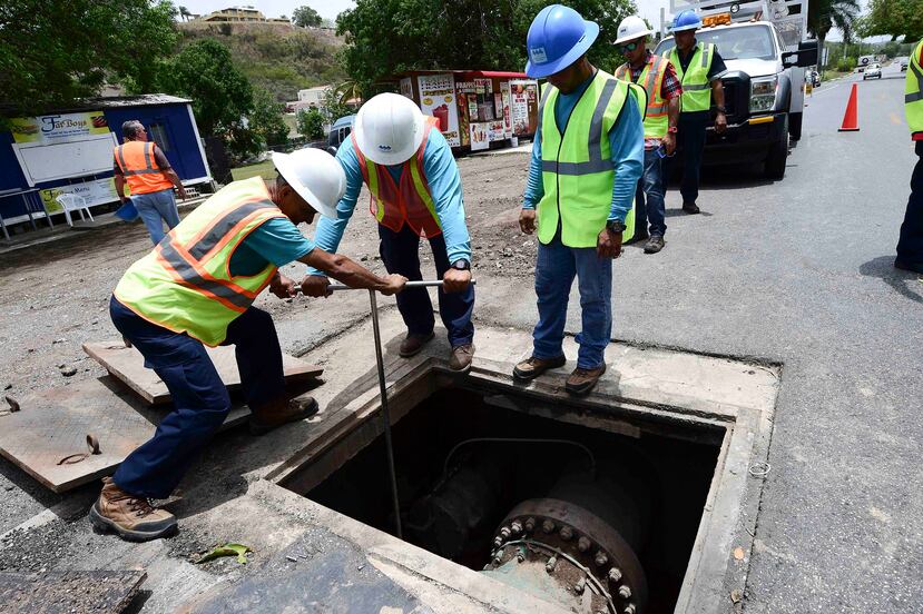 Empleados de la AAA trabajaban ayer en la limpieza de una línea de transmisión que llevará agua de Villalba a Coamo. A la derecha, arriba, el mapa muestra en marrón oscuro la zona servida por agua de pozos.