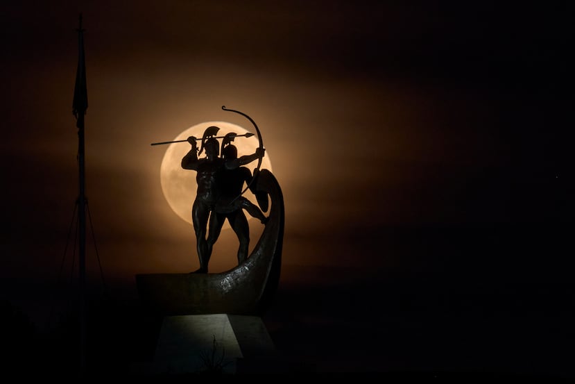 La llamada "Luna de Sangre", un color debido a la sombra de la Tierra, se ve al ponerse detrás del monumento "Salaminomachoi" en Grecia.