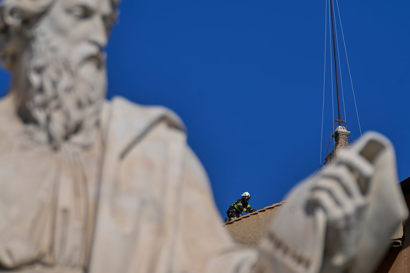 Bomberos instalan una chimenea en el tejado de la Capilla Sixtina, donde los cardenales se reunirán para elegir al nuevo papa, en el Vaticano, el 2 de mayo de 2025. (