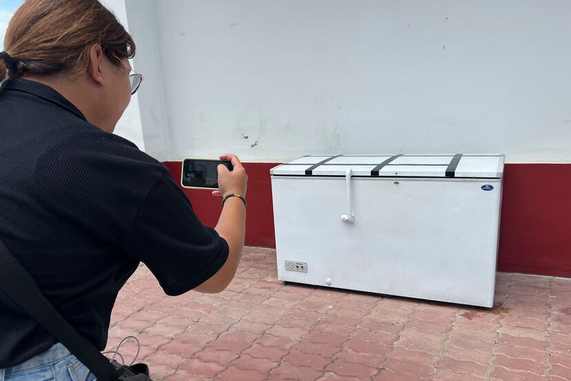 Una reportera tailandesa hace una foto a un congelador vacío en la comisaría de Nong Prue en Pattaya, provincia de Chonburi, Tailandia.