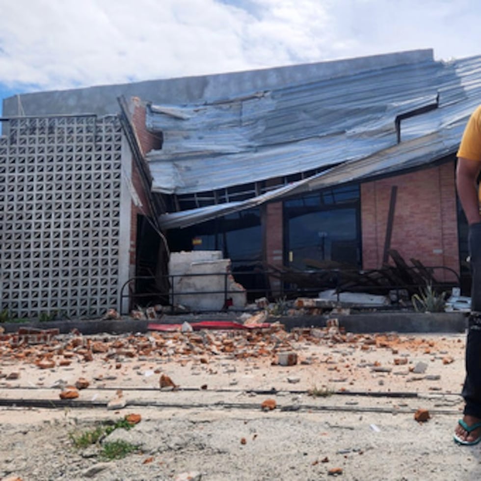 Un hombre habla por el móvil cerca de un edificio dañado por un terremoto en Palu, en Sulawesi Central.