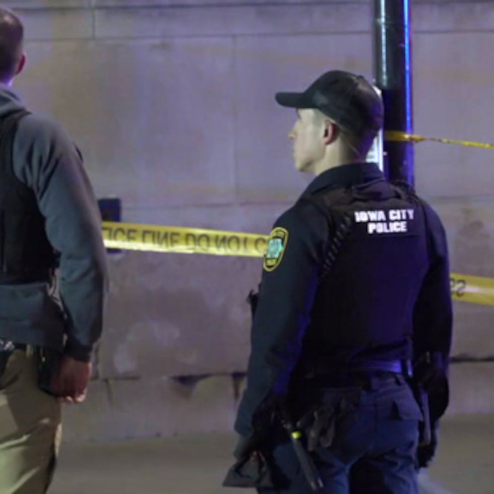 Esta imagen tomada de un video proporcionado por KCRG muestra a oficiales de policía de Iowa City trabajando en la escena de un tiroteo en el centro de la ciudad, cerca del campus de la Universidad de Iowa, el domingo 19 de abril.