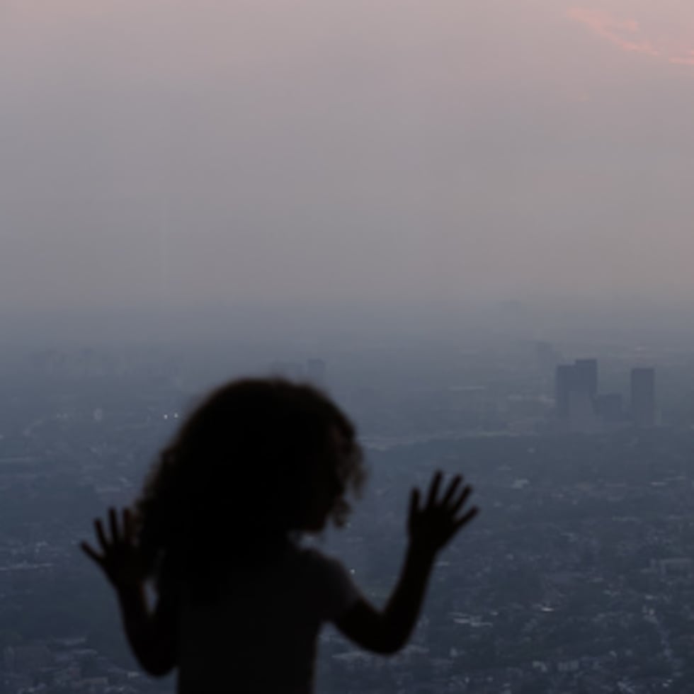 Un niño contempla el panorama desde la plataforma de observación de la Torre CN mientras el humo de los incendios forestales del noroeste de Ontario, Canadá, envuelve la ciudad de Toronto.
