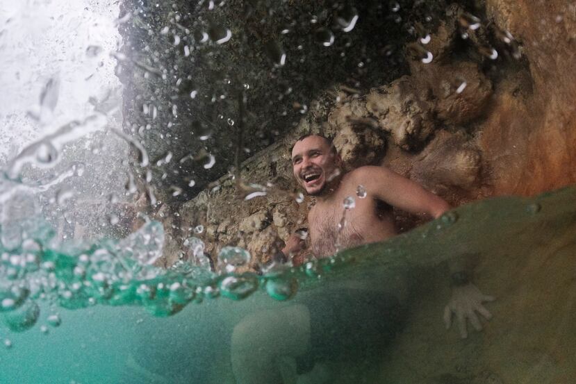 En esta imagen de archivo, un hombre se refresca bajo una cascada en un día nublado de altas temperaturas y tormentas intermitentes, en Venetian Pool, Coral Gables, Florida.