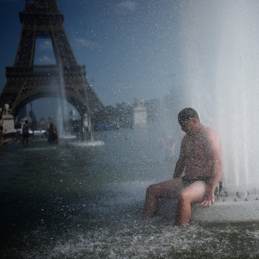 Una persona se refresca en una fuente en el Trocadero, cerca de la Torre Eiffel, durante la ola de calor que ha azotado París durante la pasada semana.