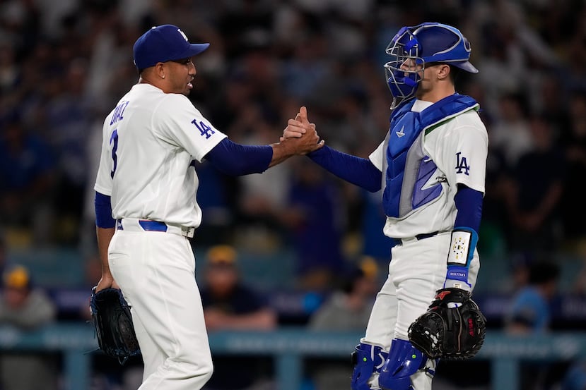Edwín Díaz y el receptor Hunter Feduccia se saludan al conseguir la victoria 3-1 de los Dodgers sobre los Brewers.