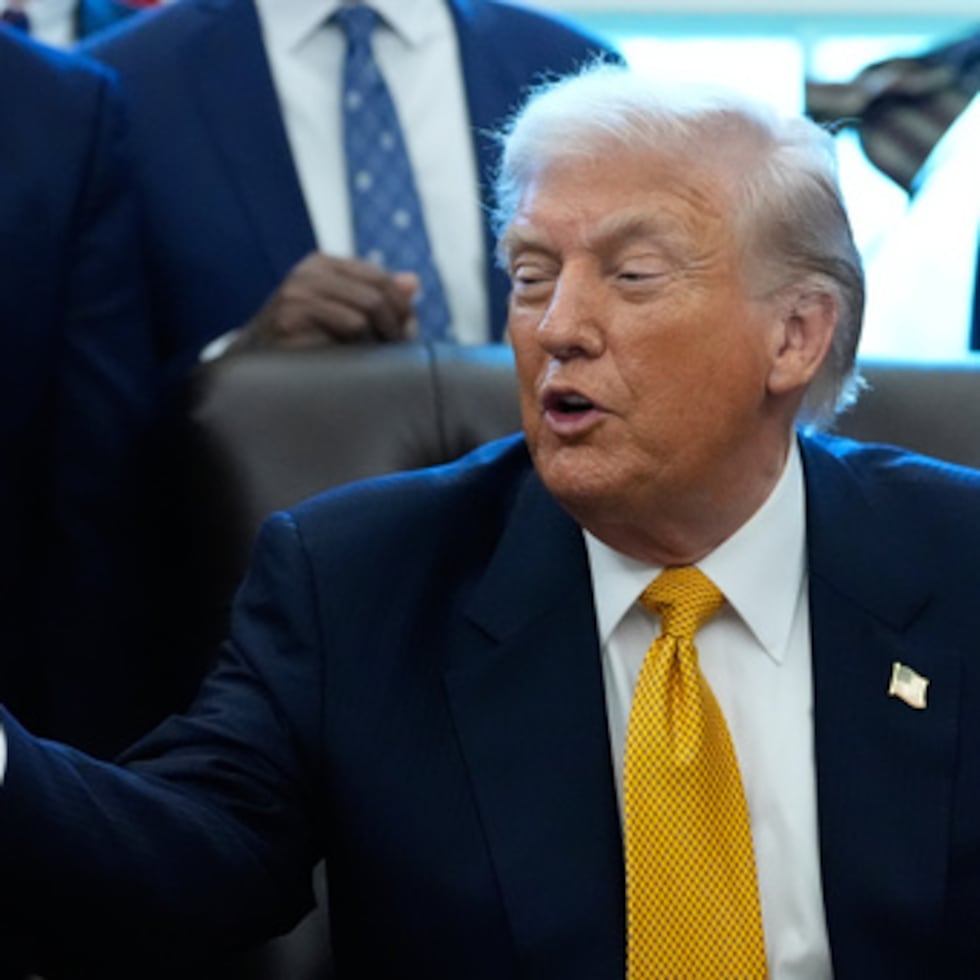 El presidente Donald Trump hace un gesto a un recipiente de leche antes de firmar un proyecto de ley que devuelve la leche entera a las cafeterías escolares de todo el país.