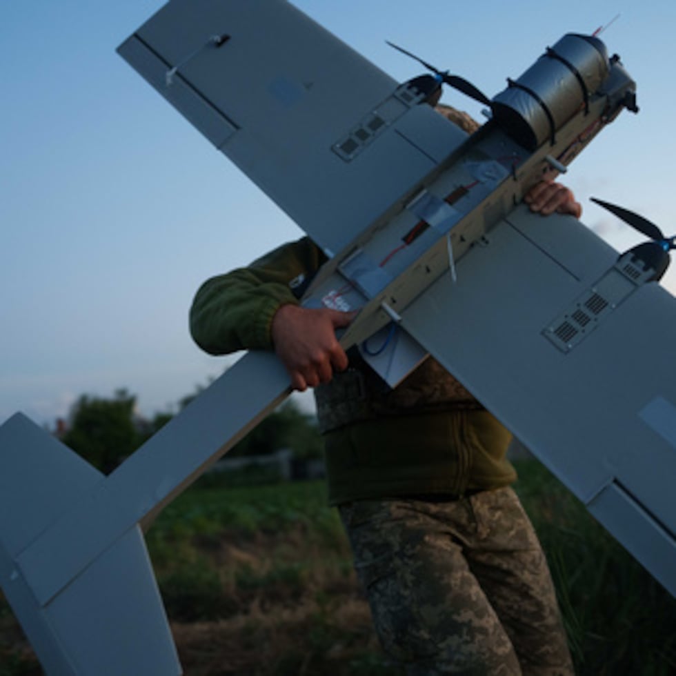 Un militar ucraniano de la brigada K-2 de las Fuerzas de Sistemas No Tripulados transporta un dron de medio alcance hasta la posición de despegue.