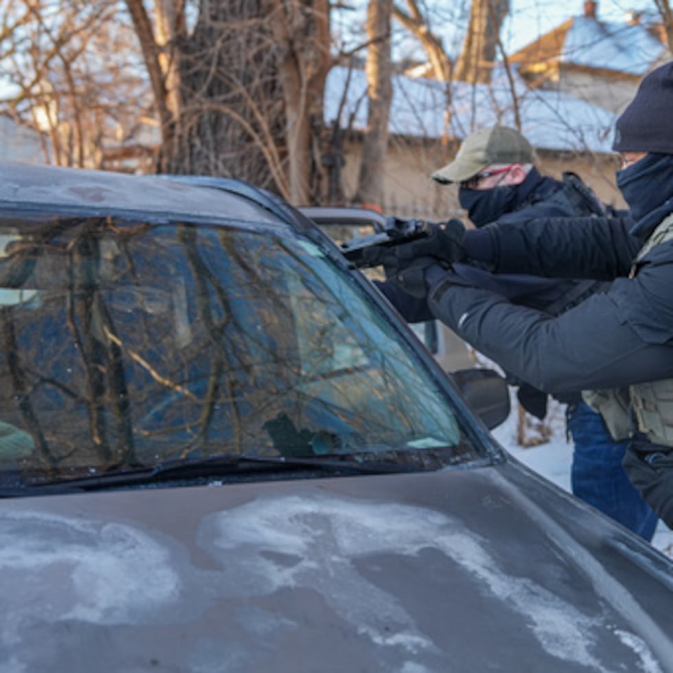 Activistas son abordados por un agente federal blandiendo un arma de fuego, por seguir vehículos de agentes, el martes 3 de febrero de 2026, en Minneapolis. (AP Photo/Ryan Murphy)