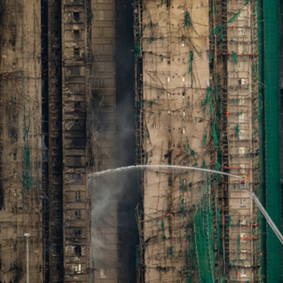 Bomberos trabajan para extinguir un incendio que comenzó el miércoles en Wang Fuk Court, un complejo residencial en el distrito de Tai Po en los Nuevos Territorios de Hong Kong, el jueves 27 de noviembre de 2025. (AP Foto/Chan Long Hei)