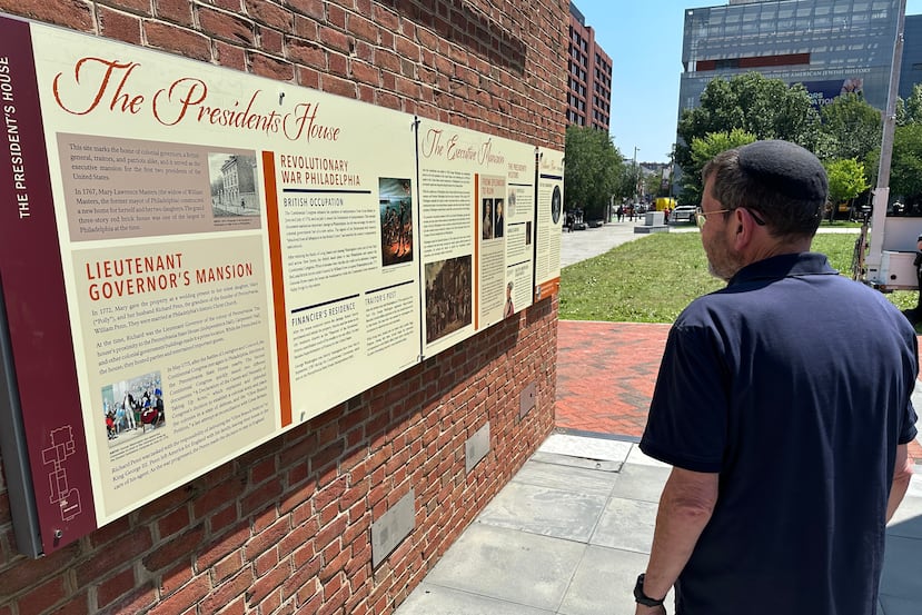 Visitantes observan los paneles educativos reinstalados sobre la esclavitud en el sitio donde se encontraba la casa del presidente George Washington en Filadelfia, el miércoles 15 de julio de 2026. (Foto AP/Tassanee Vejpongsa)
