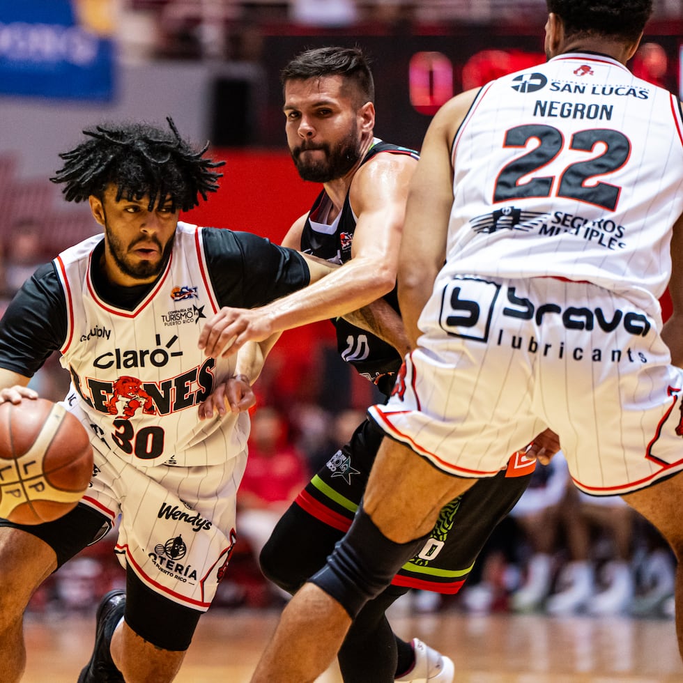 Johned Walker, de los Leones, buscar escapar de la defensa de Iván Gandía, de los Santeros, en un partido durante la temporada regular 2026 del BSN.